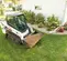 White and black BOBCAT Compact Track Loader on a lawn with dirt in the bucket
